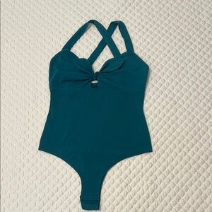 Green bodysuit with bow tie front. Great to wear with jeans, shorts or skirts.